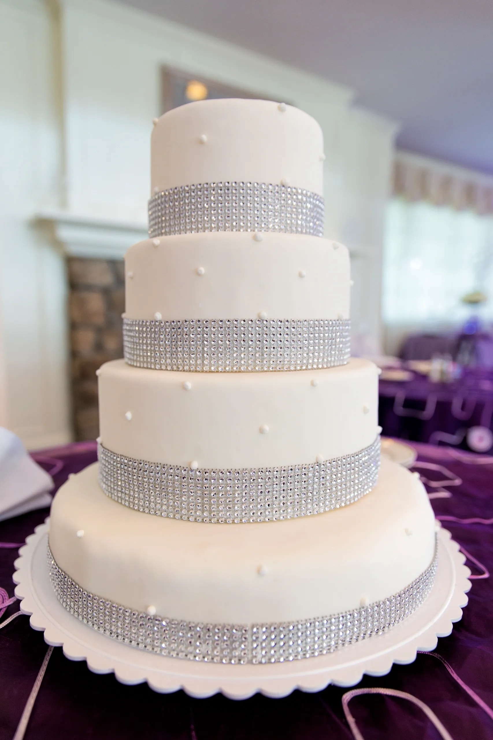 Crystal Couture — Four tiers of ivory elegance adorned with shimmering rhinestone bands — a show-stopping wedding cake that captures the glamour and romance of your most unforgettable day